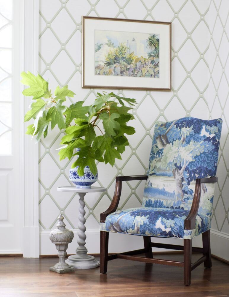 Armchair in the foyer reupholstered in a blue and white Cowtan & Tout tapestry. Oakleaf hydrangea branches in vase on table.