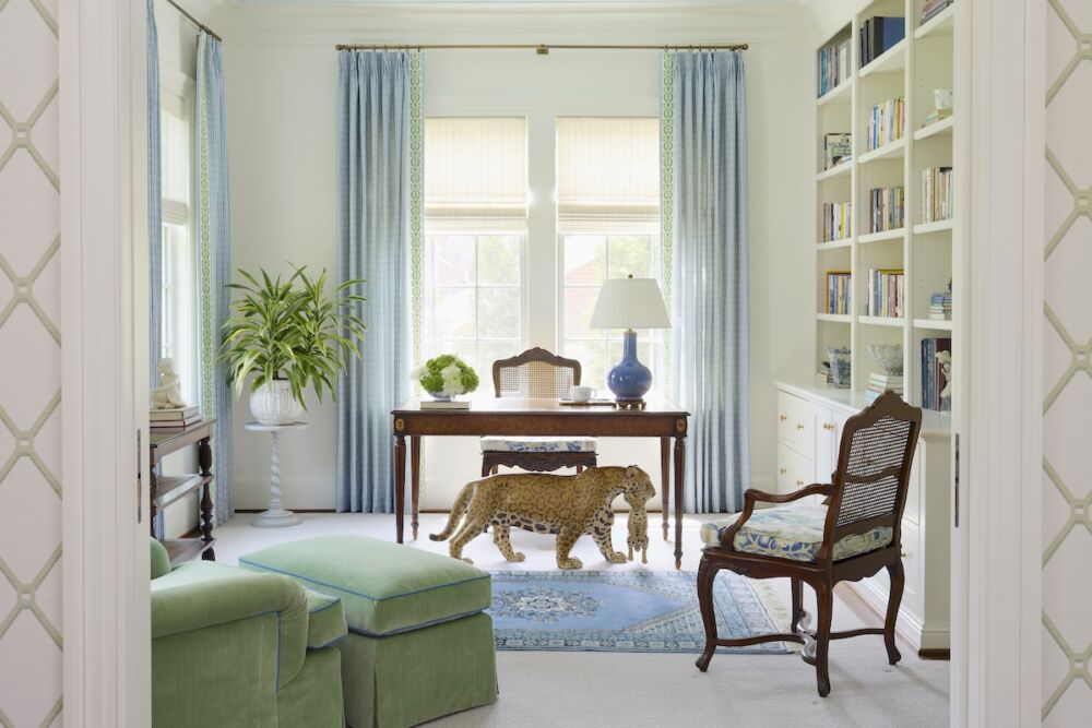 The homeowner’s study that includes her Moroccan rug, hand-carved jaguar, and desk. Kelley Proxmire employed a pale blue Lee Jofa fabric to dress the windows bordered in a cucumber green trim that ties everything together.