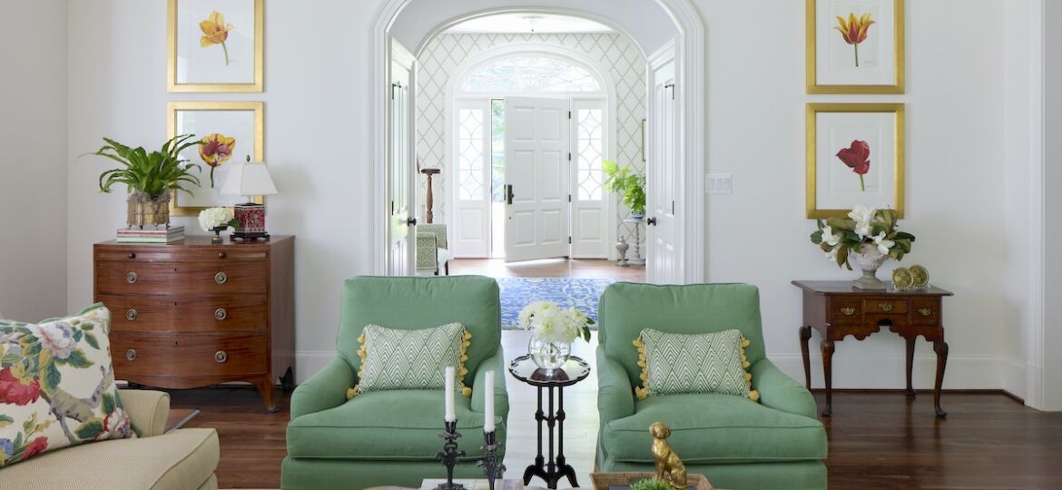 Kelley Proxmire designed family room in shades of green and warm neutrals. Armchairs recovered in a solid Romo fabric with jaunty Fabricut trim on the skirts.