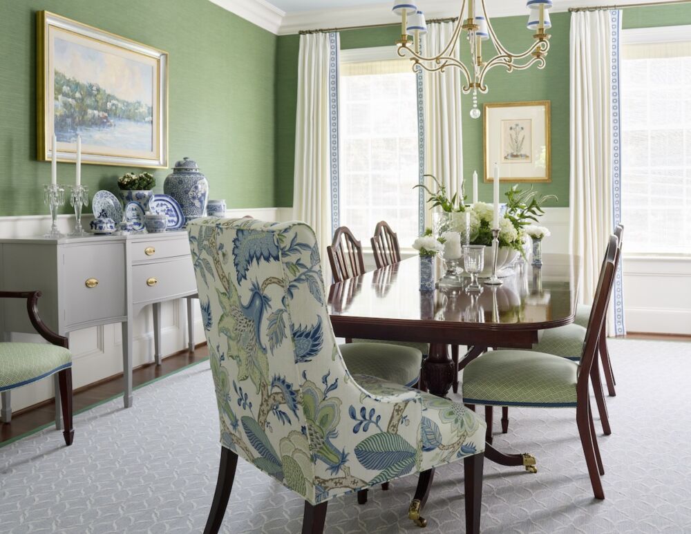 For the dining room, Kelley Proxmire used her client’s existing table and side chairs and painted the buffet a soft gray for an easy update. New hostess chairs in a large-scale Schumacher botanical print adds lively pattern against the textured grass cloth wallcovering.