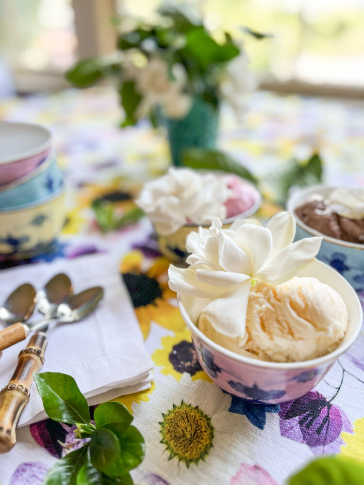 Gardenia ice cream garnishes. Vanilla, strawberry, and chocolate ice sit in pink, blue, and yellow ceramic bowls with gardenias on top.