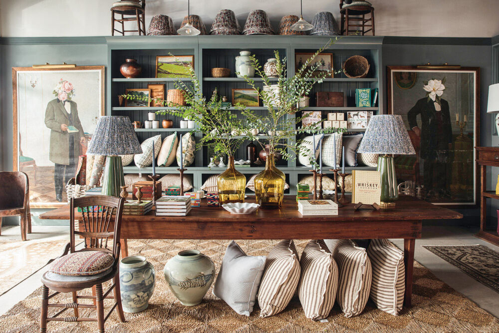 A homey teal-painted store collects striped pillows, vintage vases, and dark wooden furniture.