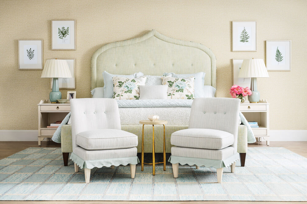 Bedroom with upholstered bed and pair of slipper chairs from Nellie Howard Ossi.