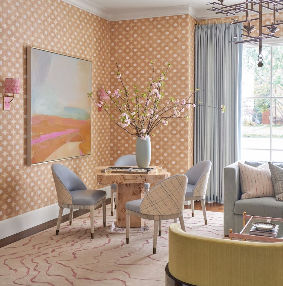 Corner of living room with game table topped with backgammon board and large vase of pink-flowering cherry branches. Interior and table design by Mary Beth Wagner.