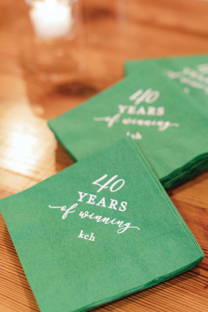 Green napkins have "40 years of winning" engraved in silver.