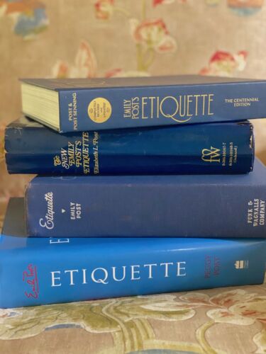 Stack of four editions of Emily Post's Etiquette stacked on chair