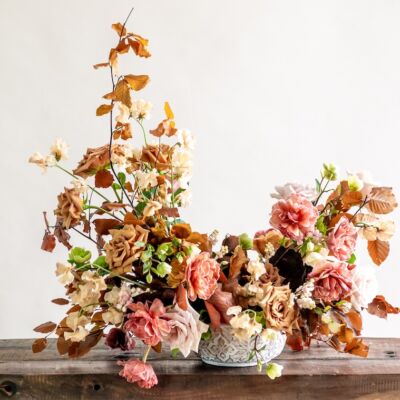 A c-shaped autumn arrangement in tones of toffee and pink by Maria Maxit
