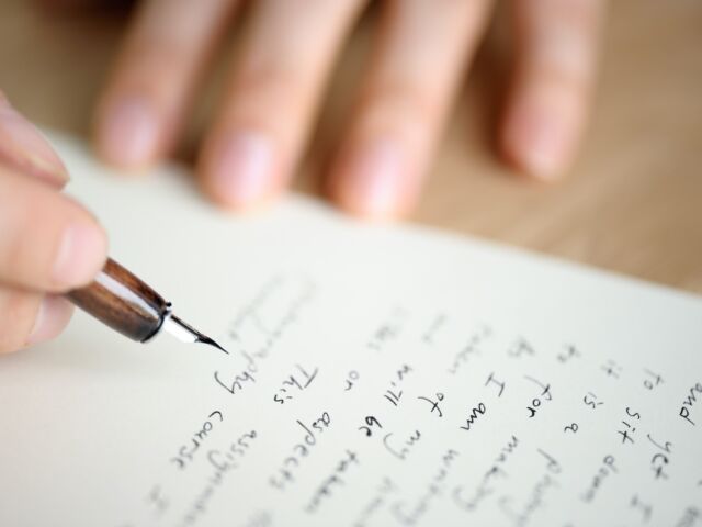 Writing letter to a friend. Selective focus and shallow depth of field.