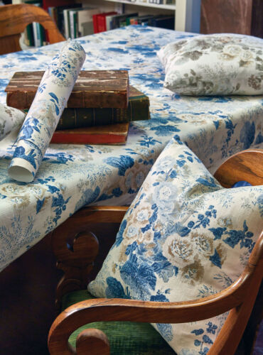 A blue floral pattern covers a pillow, a tablecloth, and some wallpaper.