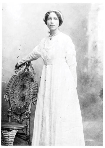 Anne Spencer stands in a white dress for a black and white photo.