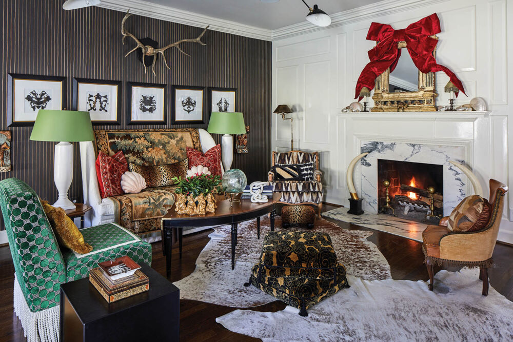 A bright red bow hangs over a white mantel in a cozy living room.