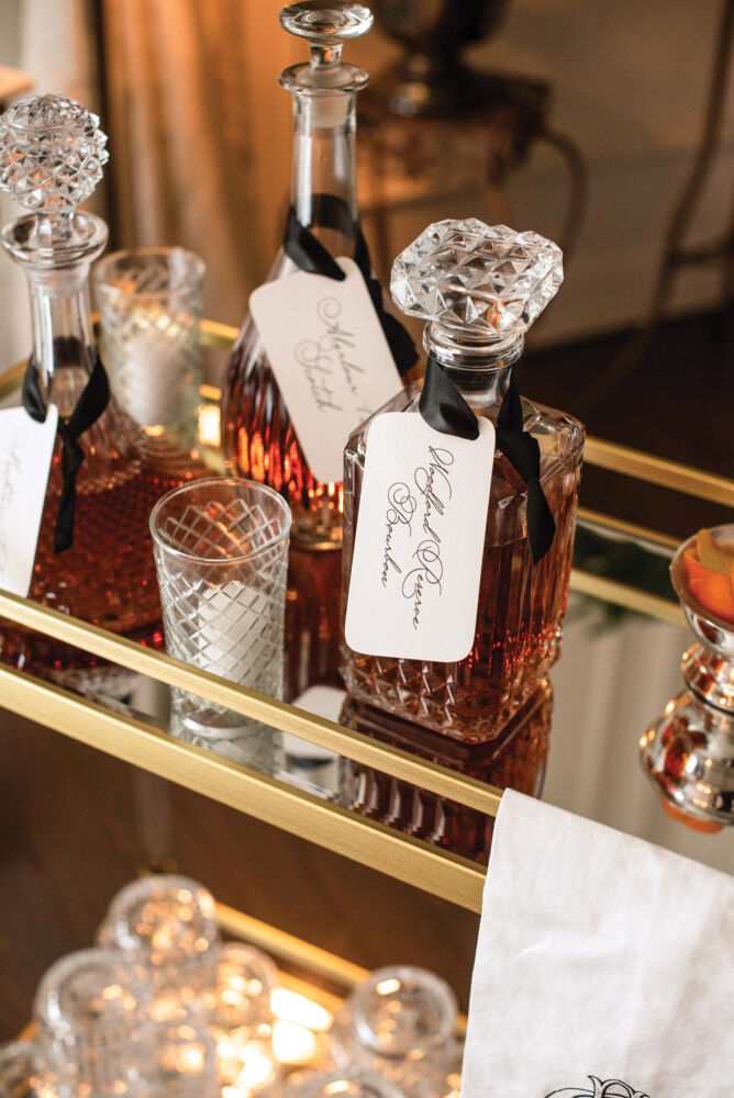 Amber colored whiskey fills a decanter on a bar cart.