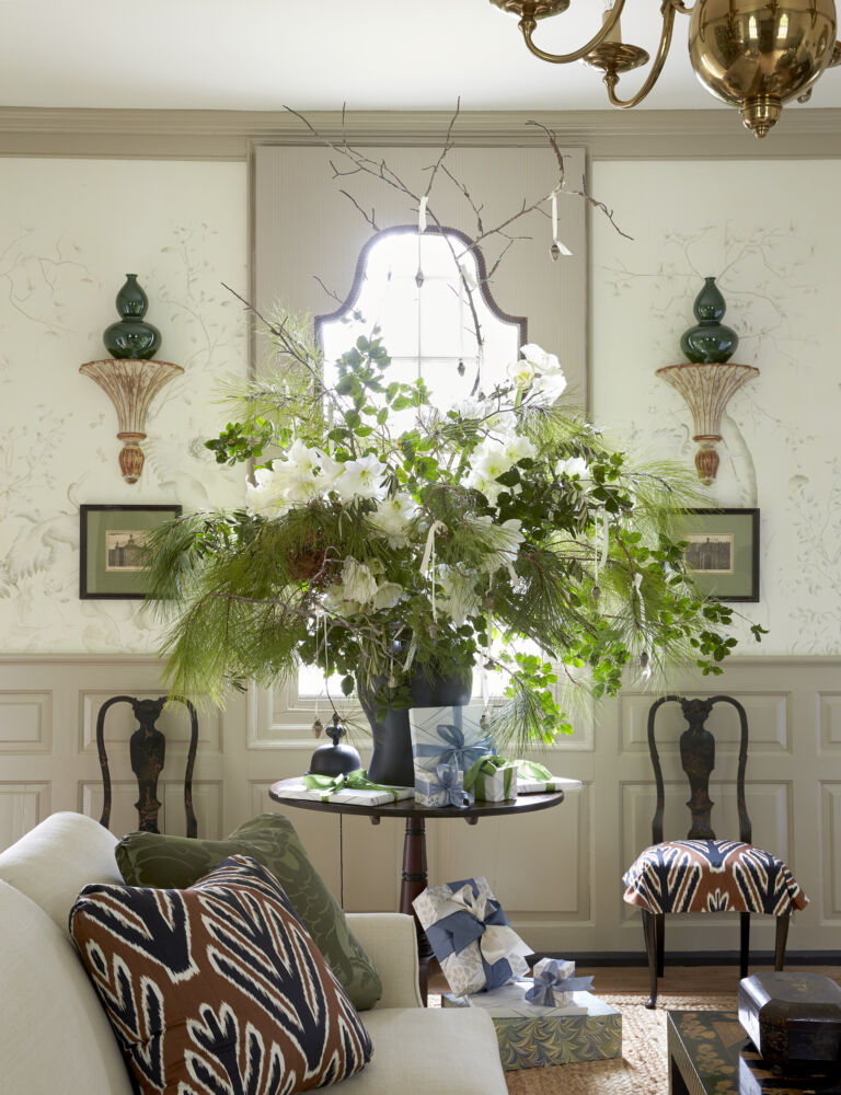 A large bouquet of white flowers are backlit by a window.