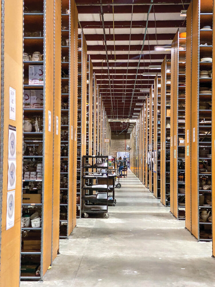 Rows and rows of shelves continue inside a ceramic warehouse.