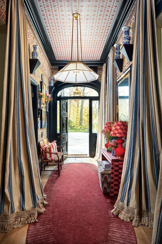 A mix of patterns and dramatic striped curtains line an entryway.