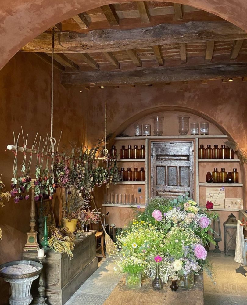The Boot Room of the Castello di Reschio, filled with cut flowers and vases. The space is used as a flower arranging room by the owner.