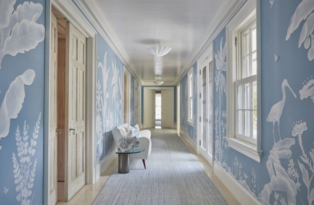 Blue wallpaper with a white floral print covers a hallway.