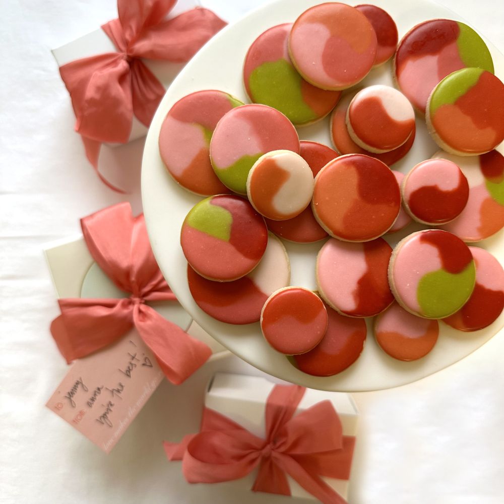 Pink and green round sugar cookies on a plate.