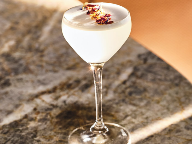 Fleur de Lis cocktail sits on a bar top.