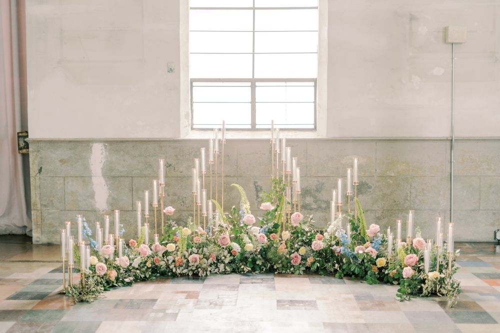 Pastel colored flowers create an arch on the floor.