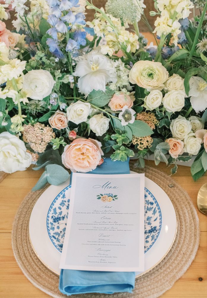 Pastel colored flowers compliment a blue and white table setting.