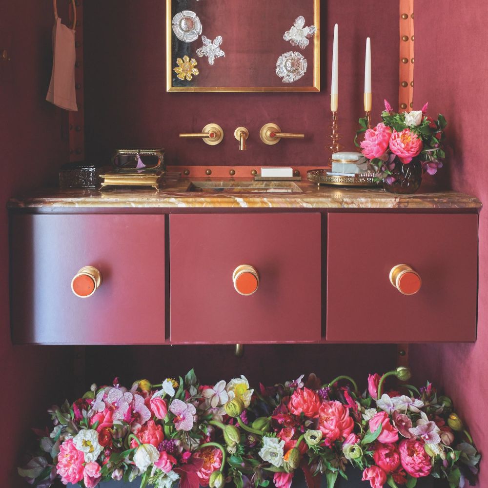 Arrangement of peonies, poppies, orchids, and tulips under powder room vanity