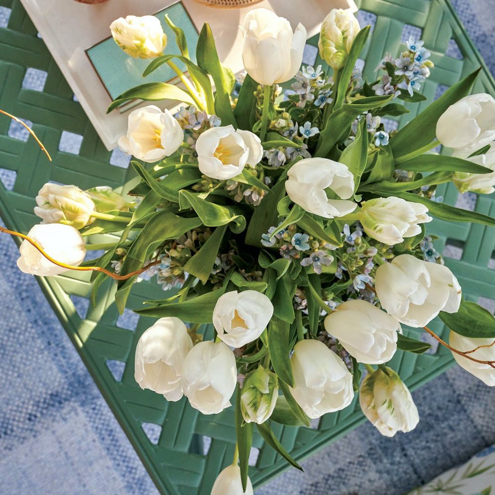Cream Tulips on top of a green lattice table.