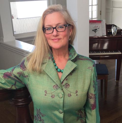 Diane Carnevale stands in a teal button up shirt.