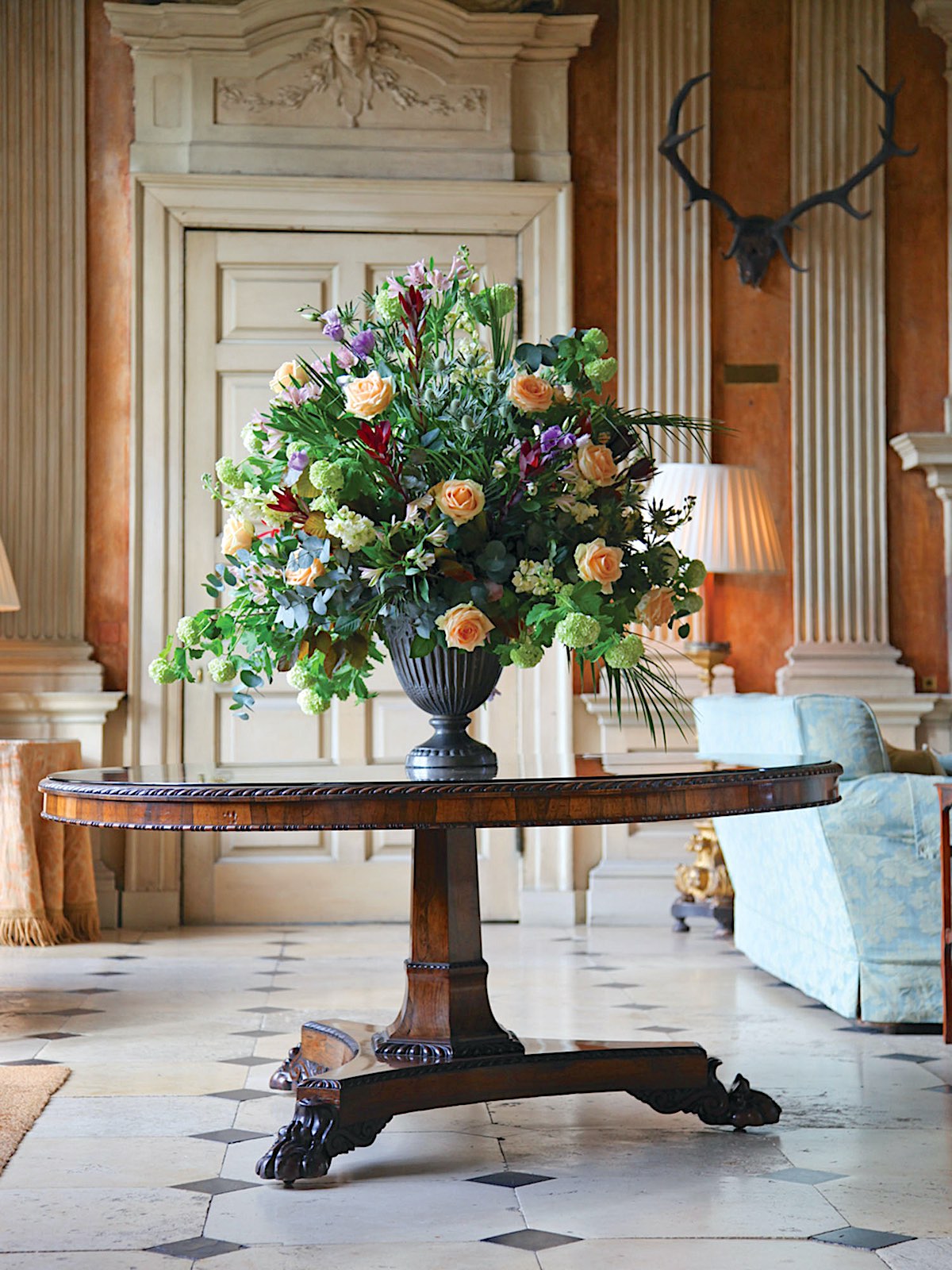 An urn of flowers welcomes in the saloon at Ditchley.