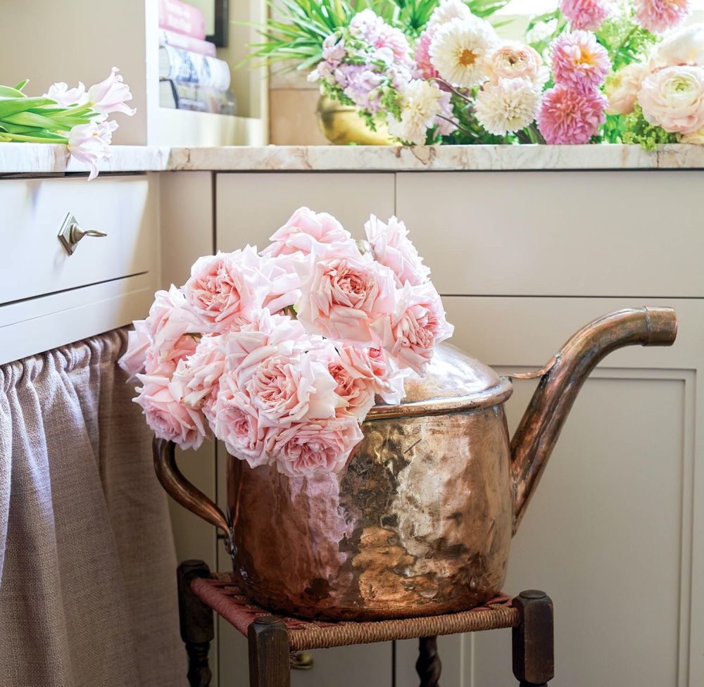 Fluffy pink roses and a copper watering can.