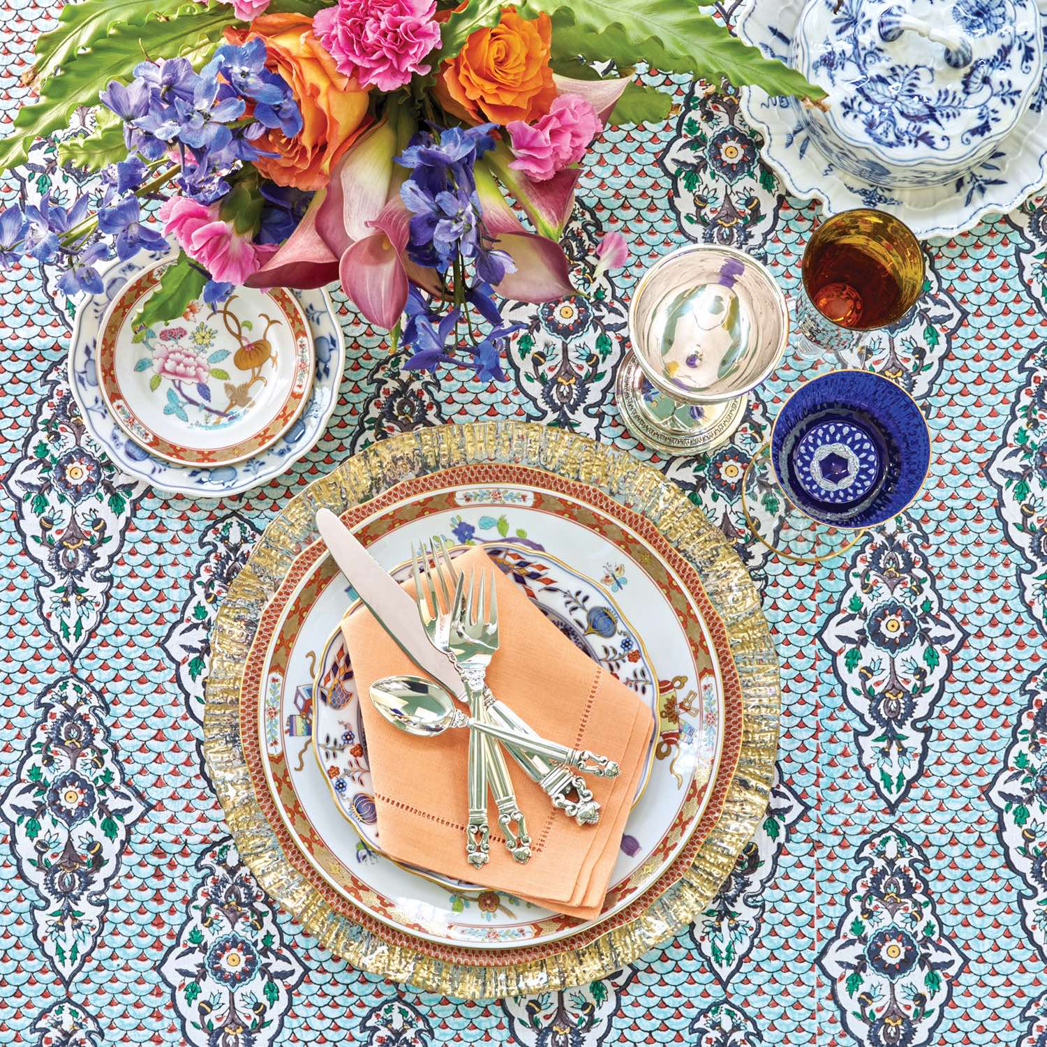 Table setting with rich hues, layered patterns, and metallic accents.