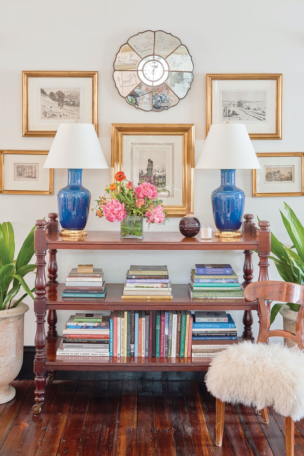 A pair of Christopher Spitzmiller lamps alongside old-world etchings and a collection of design books create a symmetrical vignette in Tammy Connor’s Charleston studio