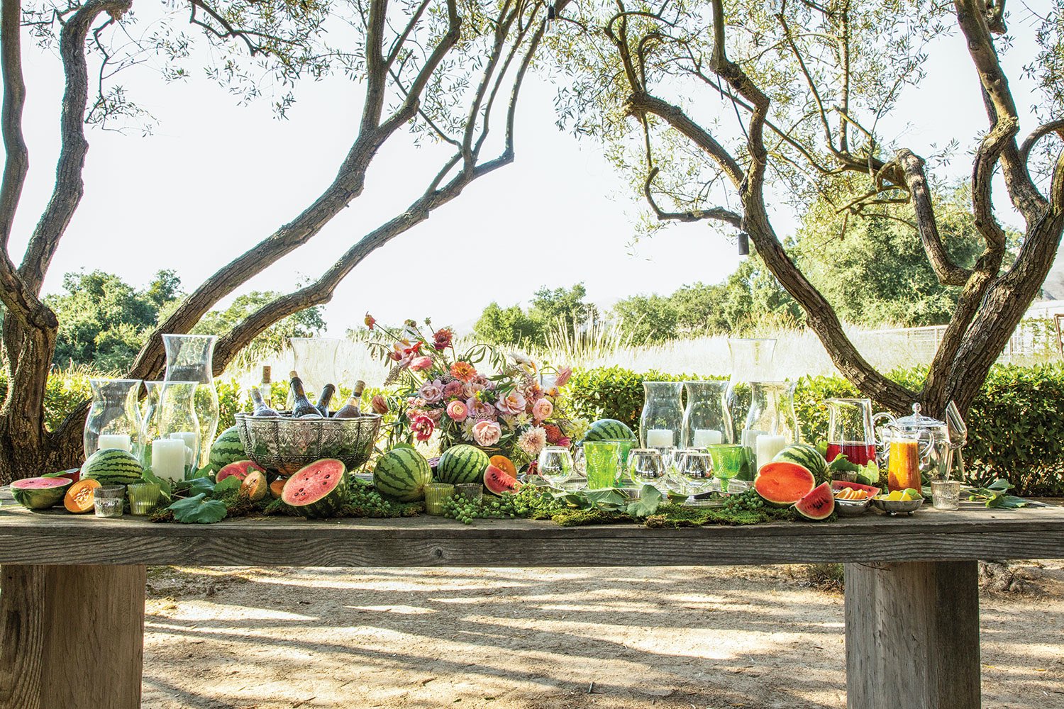 outdoor bar set with flowers, hurricane lamps, watermelons and grapes