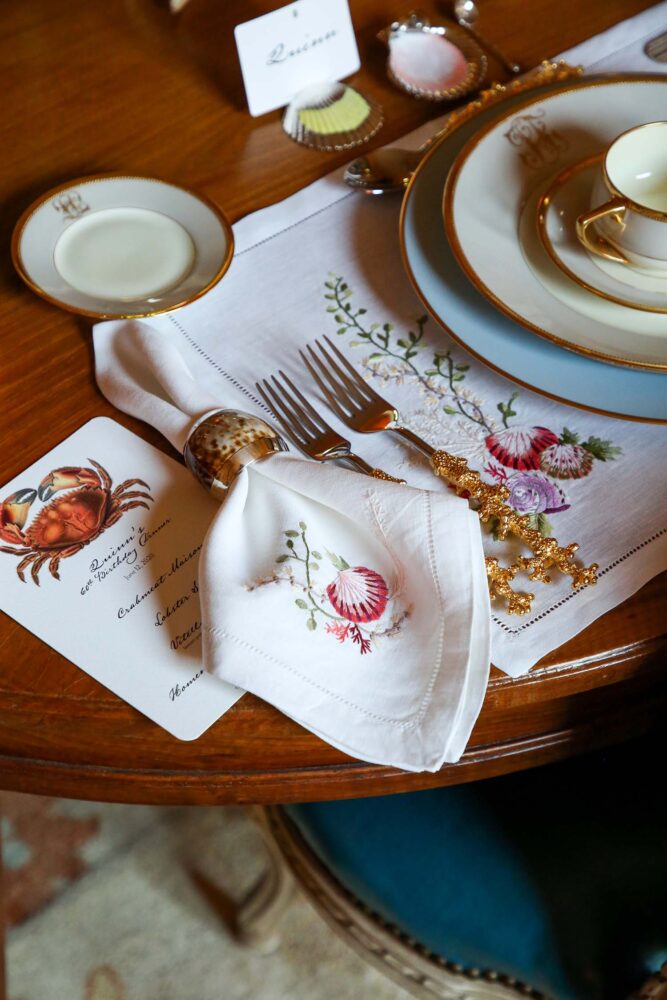 Sea-inspired embroidered linens are set at a table.