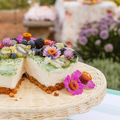 A floral cheesecake with a slice taken out.