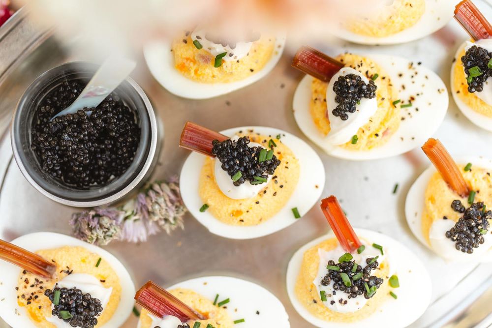 A closeup of deviled eggs with caviar and cream.