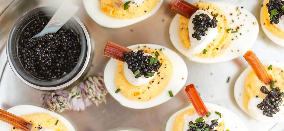 A closeup of deviled eggs with caviar and cream.