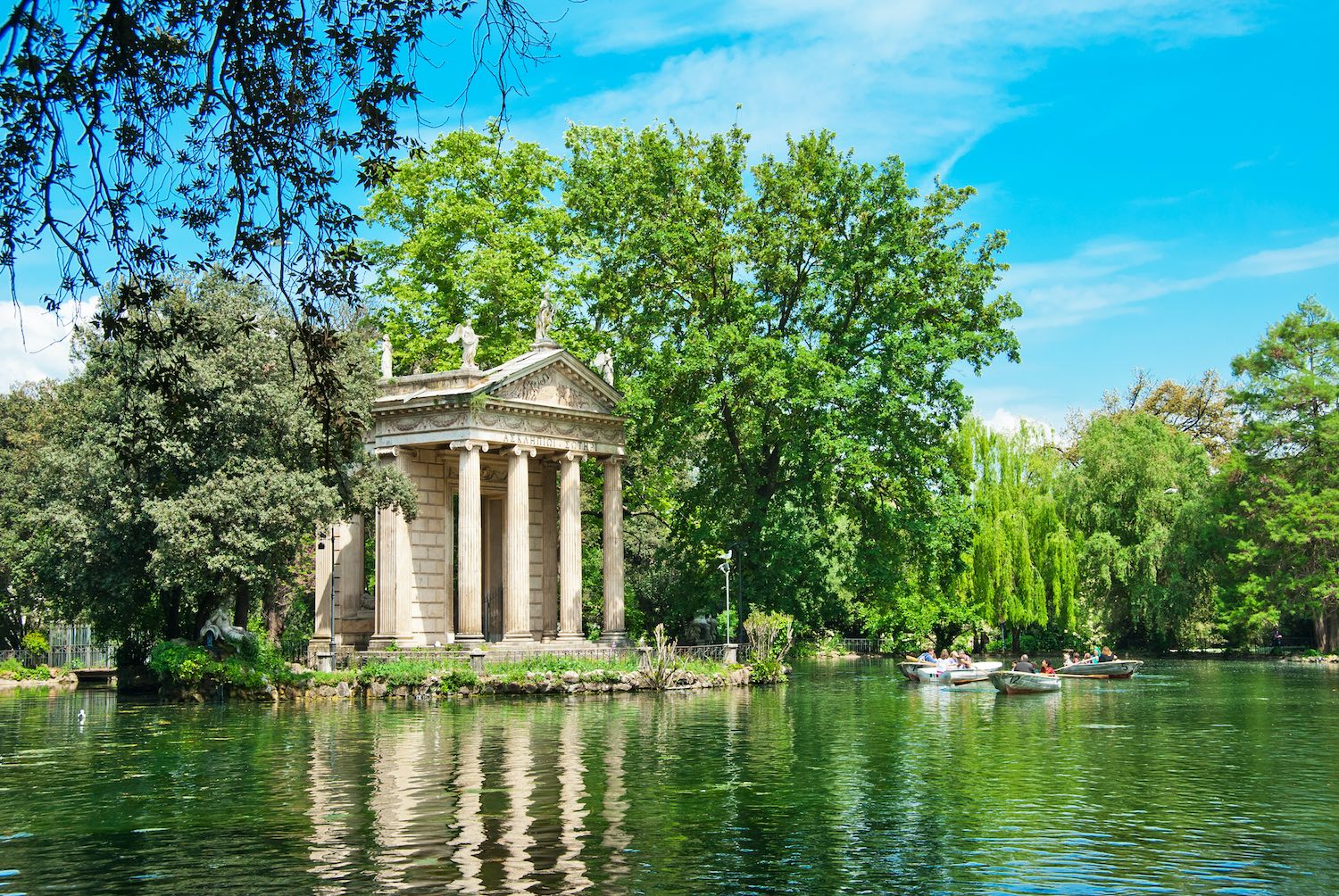 People rowing boats on water in front of Villa Borghese Pinciana, Pincian Hill, Rome, Italy