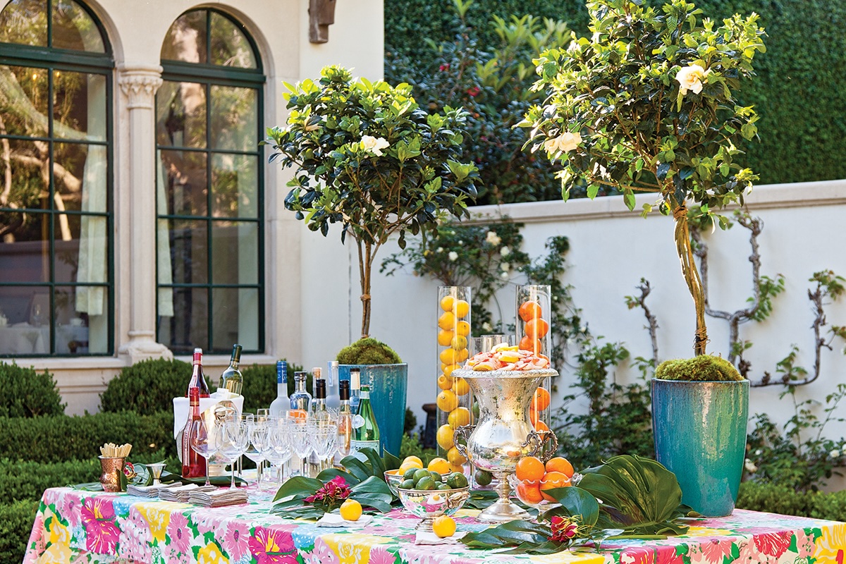 A colorful table is decorated with fruit outdoors.