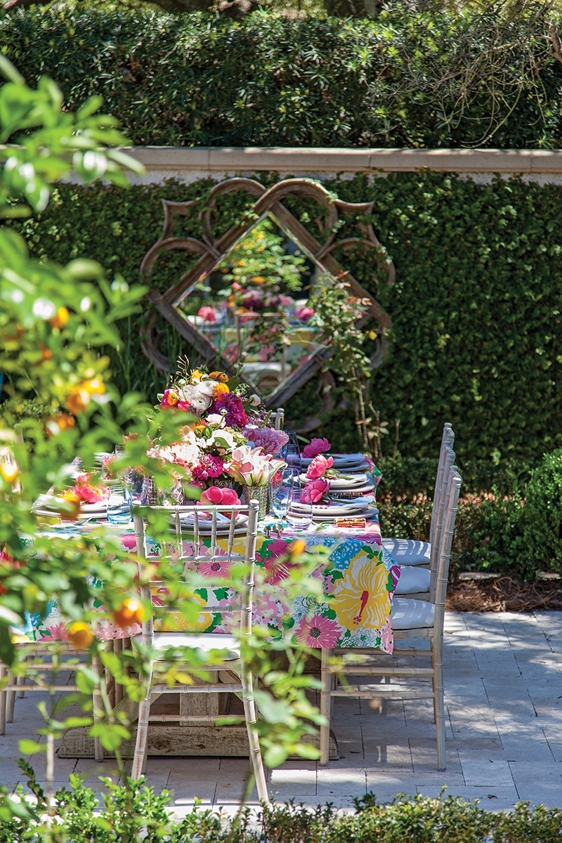 A colorful tablescape is set outside in a garden.