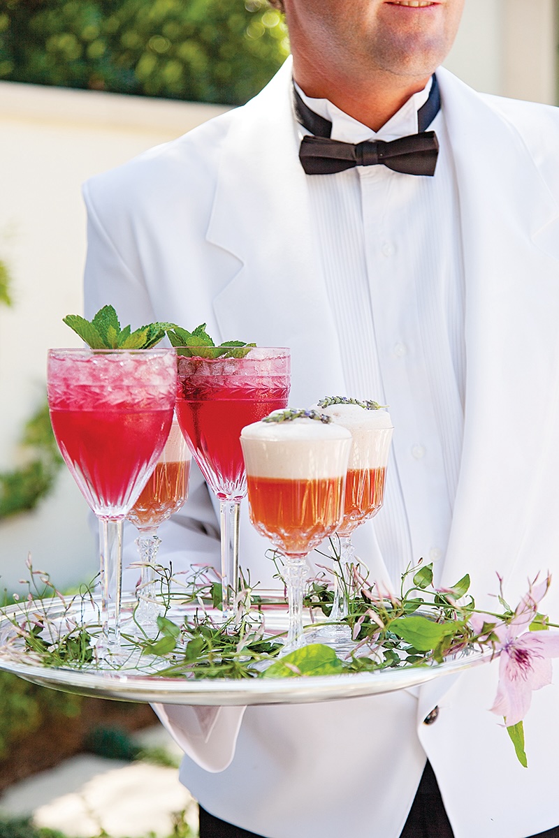 Waiter in a white suit serves drinks.