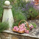 A basket of flowers sits on a stone walkway.