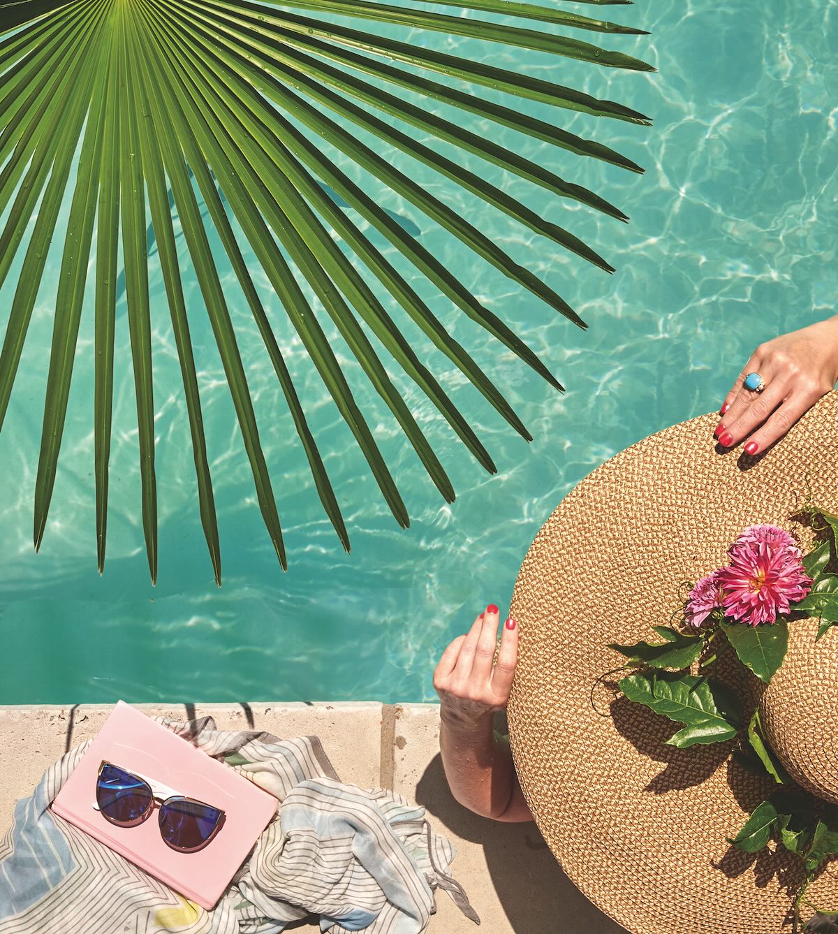 Shot from above of woman in hat by the pool.