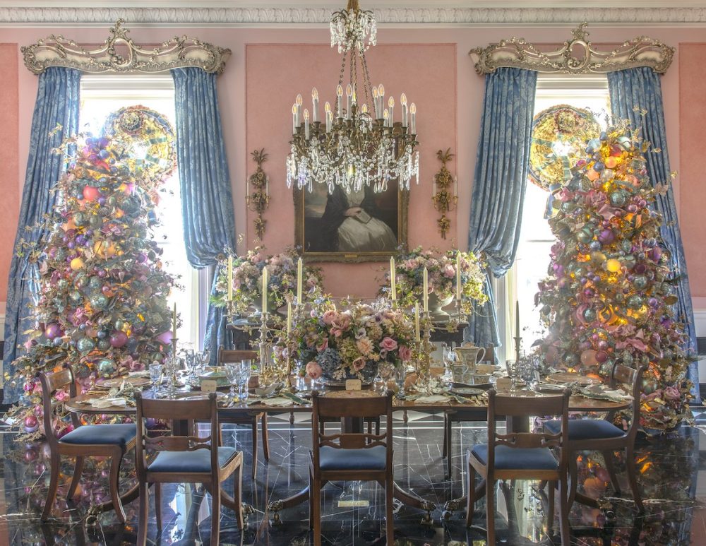Two pink and blue trees in front of windows in a dining room.