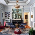 The living room reveals the transforming magic of trim detailing to create texture and luxury against the former plain walls; the ceiling molding also provides a dramatic gesture and the perfect backdrop for the Scandinavian neoclassical chandelier.
