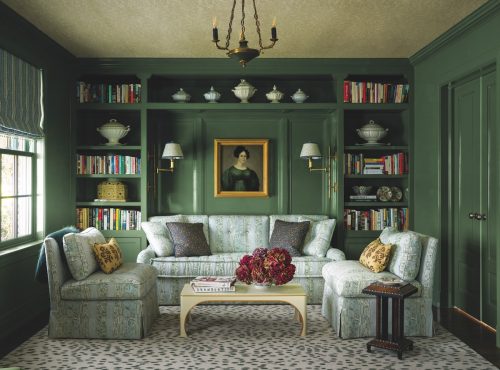 Adjacent to the primary bedroom, this sitting area is cocooned in ‘Boxwood’ by Dunn-Edwards. Bookshelves display the owners’ collection of ironstone. An early Victorian painting hangs above a sofa upholstered in a floral from Meredith Ellis Textiles.