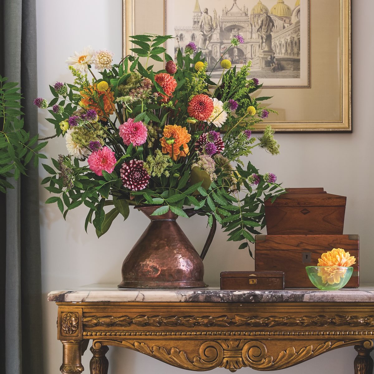 arrangement of dahlias, mums, Billy Buttons, bunny tail grass, allium, scabiosa pods, chocolate lace, and safflower orange. Branches of Chinese pistache, along with magnolias were foraged in the yard.